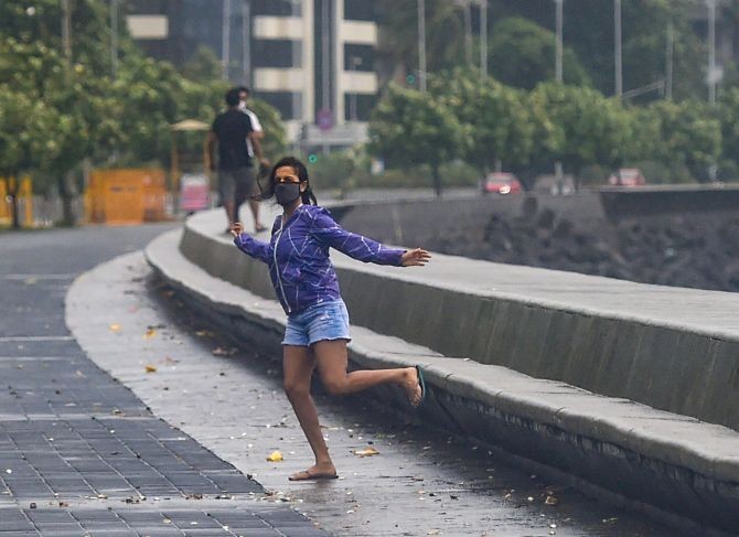 A young woman poses for photographs at Marine drive during Cyclone Nisarga, in Mumbai.  (PTI Photo/Shashank Parade)